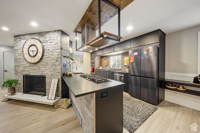 Kitchen featuring stainless steel appliances, a sink, light wood-style flooring, dark countertops, and recessed lighting | Image 4