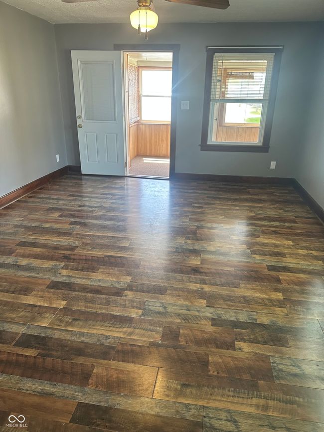 unfurnished room featuring a ceiling fan, baseboards, and dark wood-style flooring | Image 6