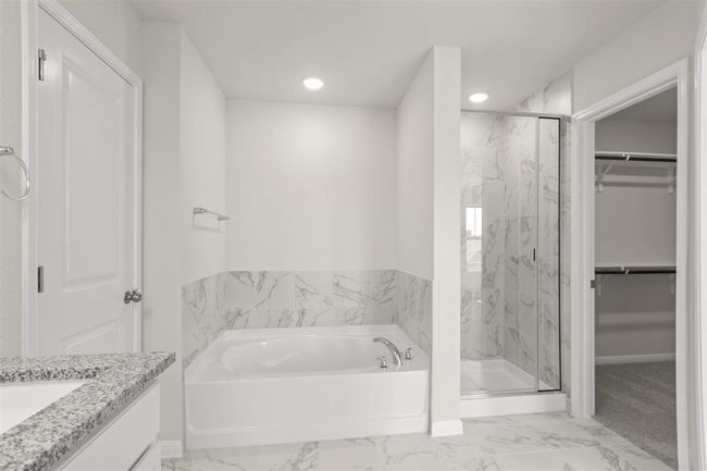 Bathroom featuring marble finish floor, a garden tub, a marble finish shower, and a walk in closet | Image 22
