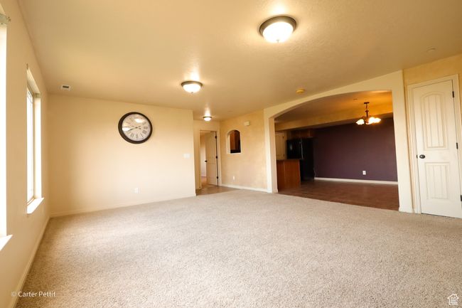 Carpeted spare room featuring arched walkways and a chandelier | Image 8