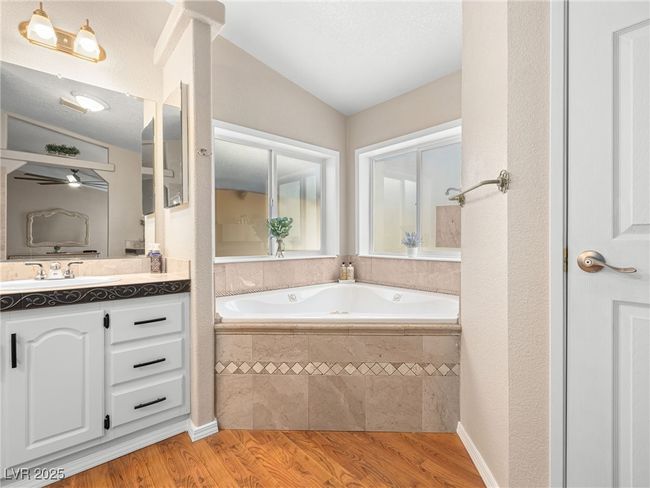Full bathroom with a garden tub, wood finished floors, lofted ceiling, ceiling fan, and vanity | Image 34