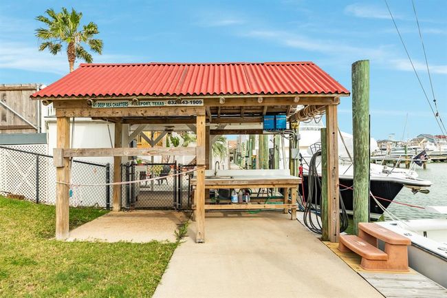 This photo shows a canal front dock area with a covered fish-cleaning station topped by a red roof. It's adjacent to a marina with boats, offering convenient access for boating and fishing enthusiasts. | Image 36