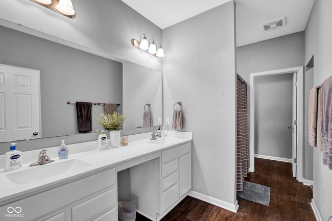 full bath with double vanity, visible vents, a sink, and wood finished floors | Image 18