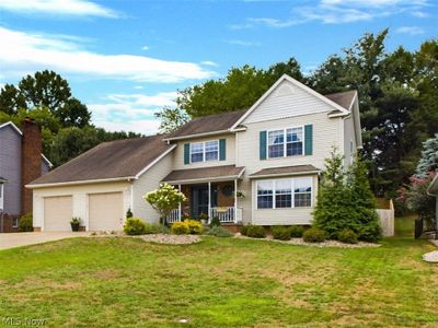 View of front of property with a porch, a garage, and a front lawn | Image 1