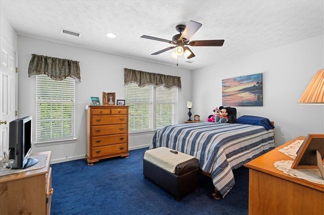 The primary bedroom has large windows, recessed lighting, and a ceiling fan with light. | Image 17