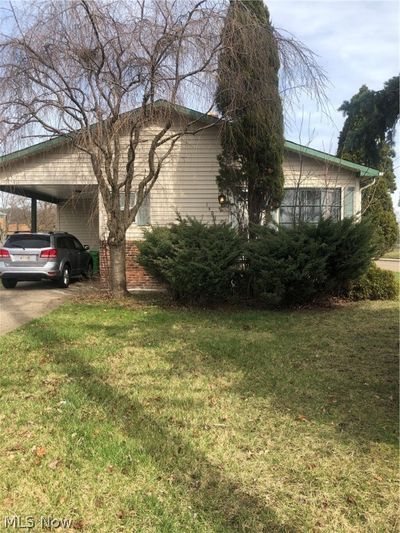 View of home's exterior with a carport and a lawn | Image 1