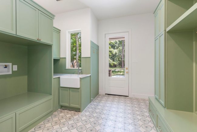 Mud and laundry room off the garage with its own entrance, sink, and plenty of storage. | Image 23