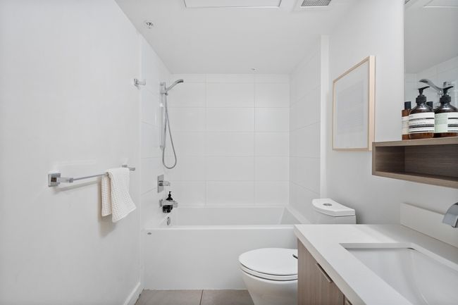 Bathroom featuring vanity, tile patterned flooring, visible vents, shower combination, and toilet | Image 18