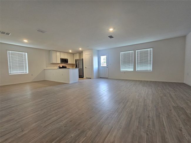 Unfurnished living room with baseboards, visible vents, and wood finished floors | Image 4