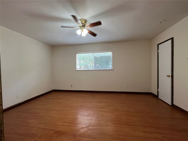 Unfurnished room with ceiling fan, wood finished floors, and baseboards | Image 12
