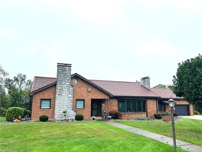 View of front of home featuring a front yard and a garage | Image 1