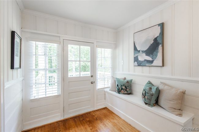 Beautiful breezeway with built-in bench, custom blinds, and door to deck | Image 16