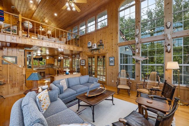 Seamlessly connected, the second-floor living space flows effortlessly into the adjoining dining and kitchen areas. This well-designed configuration creates an ideal environment for hosting indoor and outdoor gatherings, offering a seamless transition between spaces. Enhancing the allure of entertaining, a spacious screened-in porch finds its place between the kitchen and living area, serving as an inviting bridge between interior comfort and the refreshing outdoors. | Image 13
