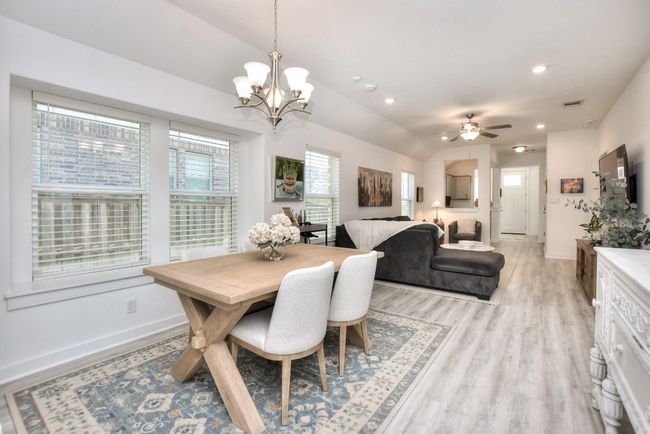 Dining room with baseboards, vaulted ceiling, recessed lighting, light wood finished floors, and ceiling fan with notable chandelier | Image 11