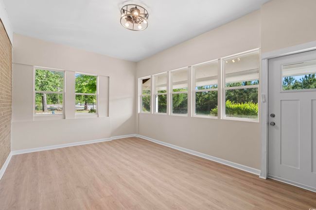 Empty room with wood finished floors and a chandelier | Image 13