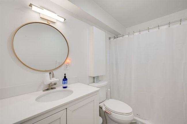 Full bath with toilet, vanity, and curtained shower | Image 13
