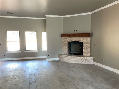 Unfurnished living room with crown molding, a fireplace, and hardwood / wood-style floors | Image 3