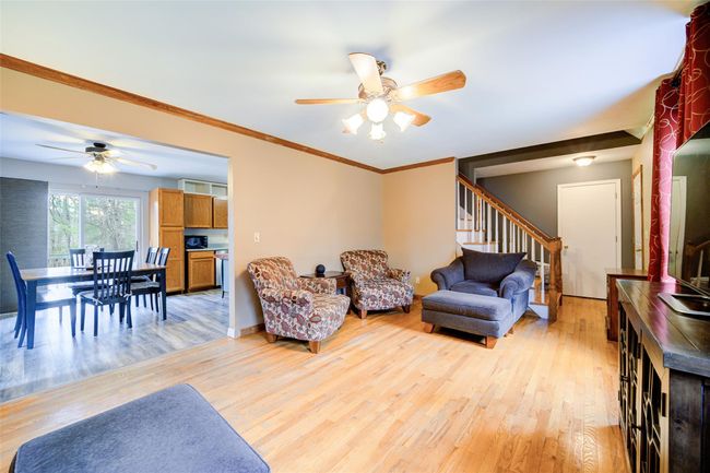 Living area with stairway, a ceiling fan, crown molding, and light wood-style flooring | Image 7