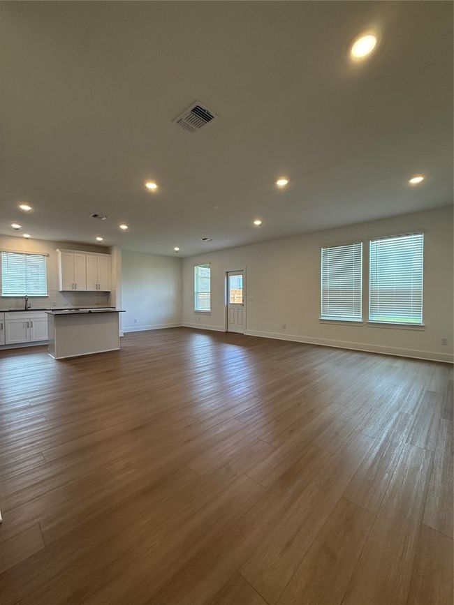 Unfurnished living room with recessed lighting, baseboards, wood finished floors, and a sink | Image 12