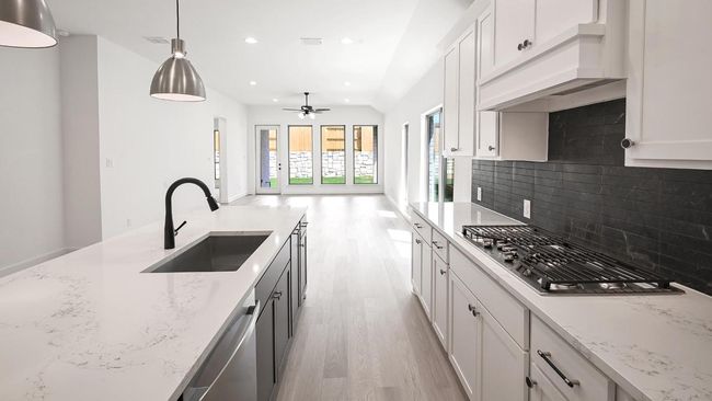 Kitchen with white cabinetry, light wood finished floors, appliances with stainless steel finishes, recessed lighting, and decorative light fixtures | Image 16