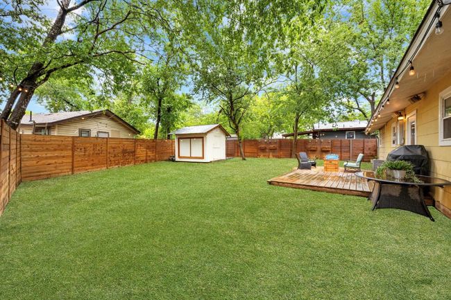 Fenced backyard featuring a deck and a storage shed | Image 20
