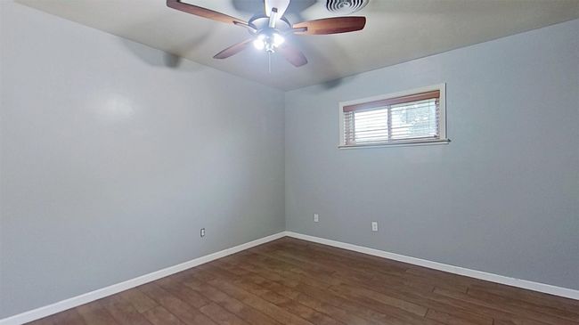 Spare room featuring dark wood-style flooring, baseboards, and a ceiling fan | Image 15