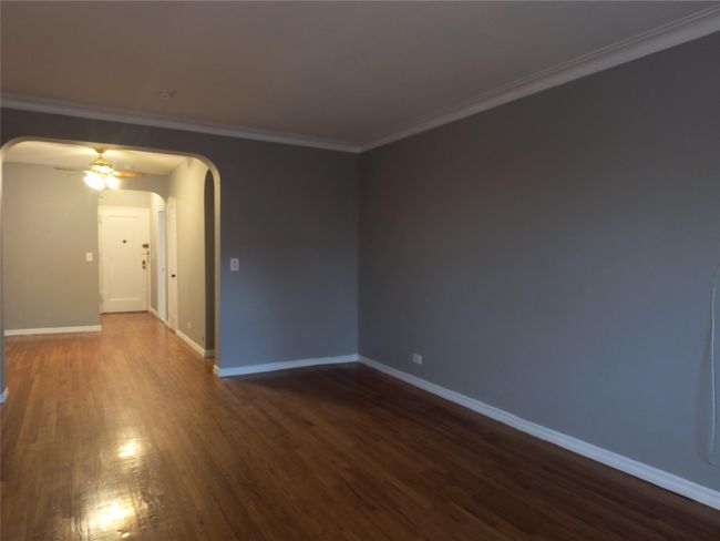 Unfurnished room with dark wood-type flooring, a ceiling fan, arched walkways, and baseboards | Image 17