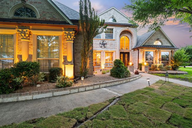 View of front facade with brick siding, a porch, and a standing seam roof | Image 4