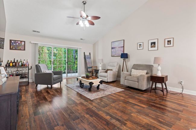 Living area featuring a ceiling fan, dark wood finished floors, and high vaulted ceiling | Image 9