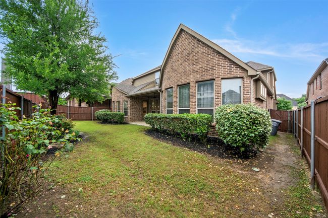 Rear view of property featuring a lawn, a fenced backyard, and brick siding | Image 38