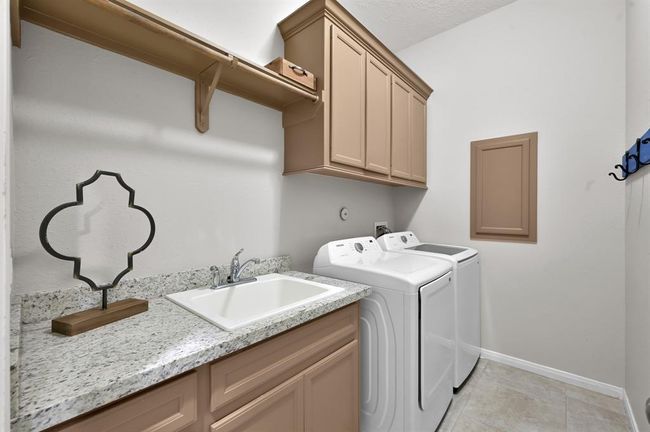 Utility room off the garage with sink & storage. | Image 32
