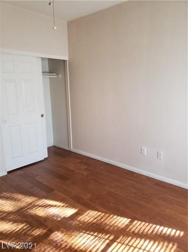 Unfurnished bedroom featuring dark wood finished floors and a closet | Image 13