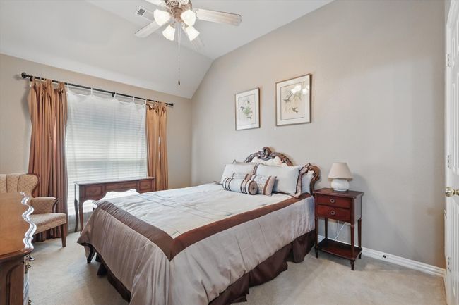 Bedroom featuring light carpet, lofted ceiling, baseboards, and ceiling fan | Image 23
