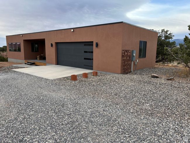 View of front facade with stucco siding, a garage, and concrete driveway | Image 44