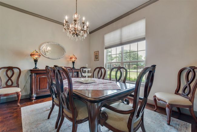 Dining space featuring a chandelier, ornamental molding, and wood finished floors | Image 10