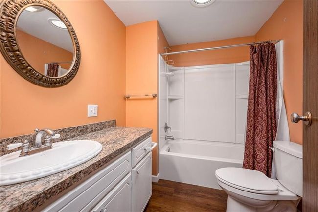 Bathroom featuring shower / bath combination with curtain, toilet, vanity, and wood finished floors | Image 20
