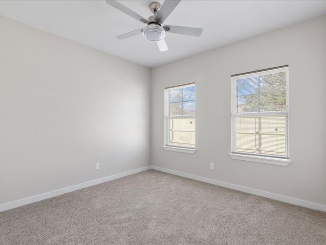 Spare room featuring light colored carpet, baseboards, and ceiling fan | Image 24