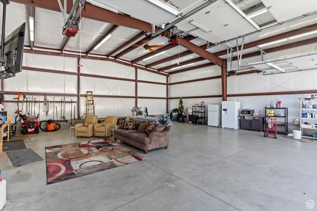 Garage with freestanding refrigerator, white refrigerator with ice dispenser, and a garage door opener | Image 25