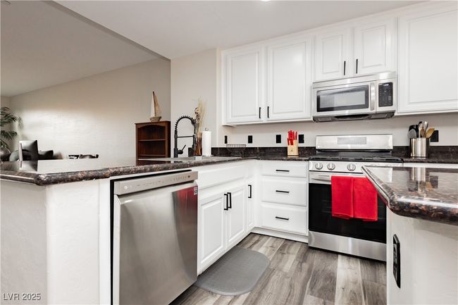 Chefs kitchen with white cabinets, granite countertops and stainless steel appliancees | Image 10