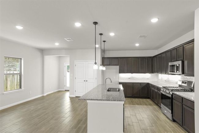 Kitchen featuring visible vents, a sink, light stone counters, and appliances with stainless steel finishes | Image 16