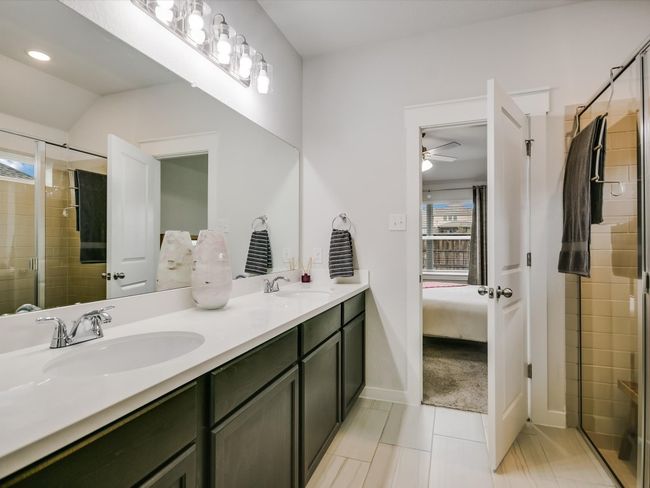 Love the tile and single counter, double vanity! It elongates and accentuates the privacy and functionality of the shower area! the 3D video shows the enormity of the walk through closet, too! The design simplifies laundry time, as well because the closet is connected to the laundry room that is accessible through the kitchen! Easy Breezy! | Image 12