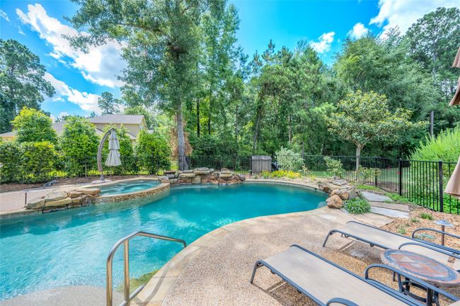 Experience luxury with a heated saltwater pool featuring a sunning ledge and three enchanting waterfalls. | Image 33