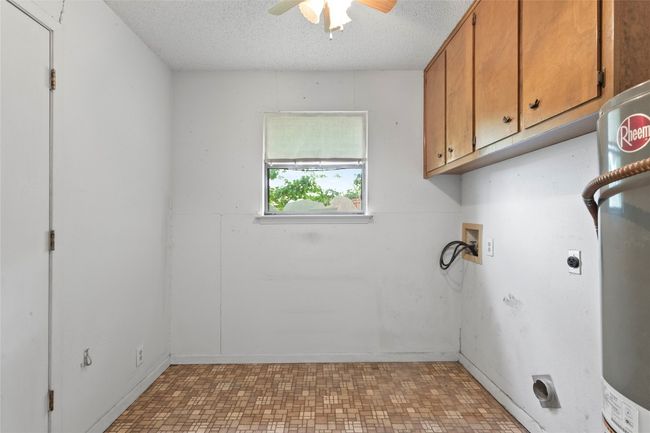 Washroom with electric dryer hookup, cabinet space, ceiling fan, a textured ceiling, and hookup for a washing machine | Image 10