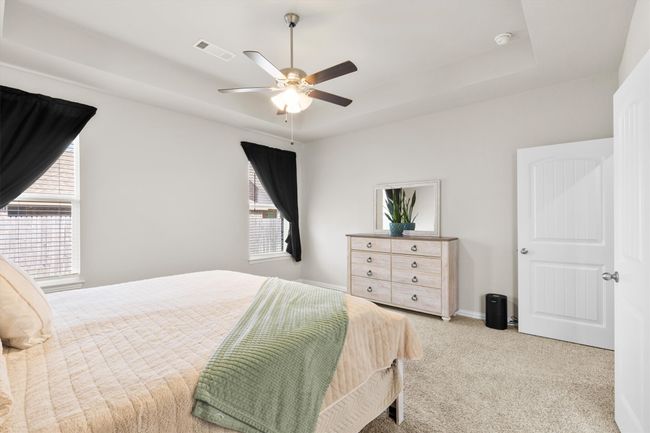 Bedroom with multiple windows, a tray ceiling, and carpet | Image 20