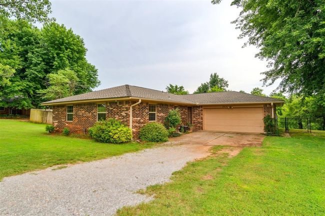 Ranch-style home featuring driveway, a garage, brick siding, and a shingled roof | Image 4
