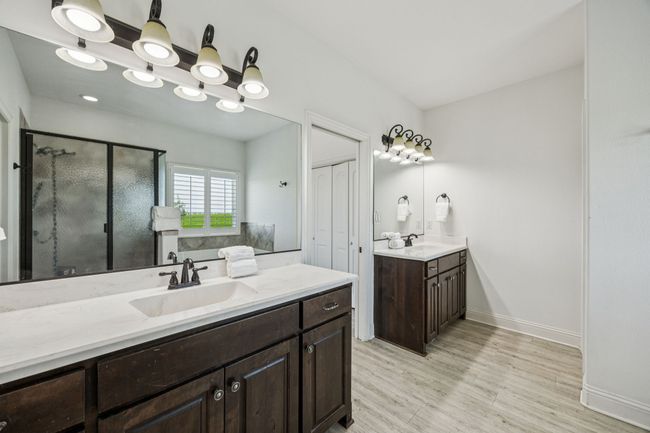 Bathroom with a shower stall, wood finished floors, and two vanities | Image 12