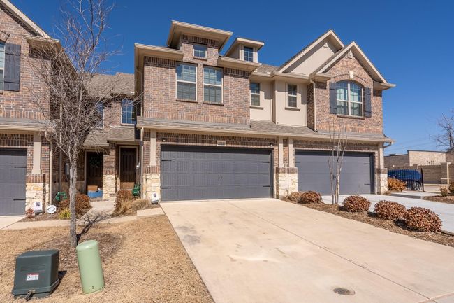 Multi unit property with a garage, brick siding, concrete driveway, and a shingled roof | Image 22
