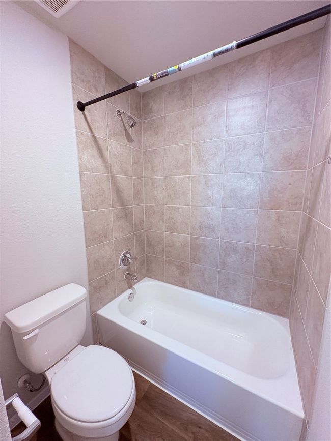 Full bath featuring shower / washtub combination, wood finished floors, and toilet | Image 18