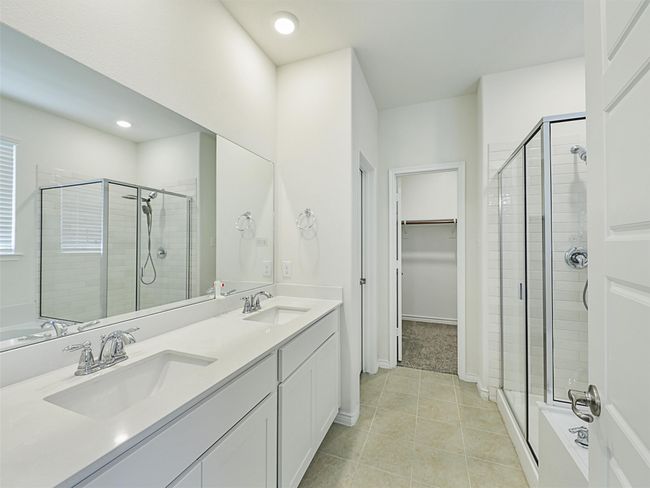 Full bath featuring a stall shower, double vanity, a spacious closet, tile patterned flooring, and recessed lighting | Image 15