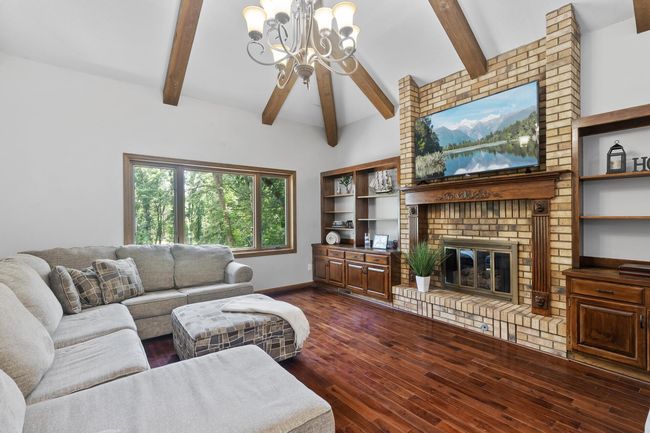 Vaulted beam ceiling family room main level, with gas burning fireplace enhanced with Mahogany built-in cabinets and shelving. Hardwood floors and a new picturesque window overlooking side of lot. | Image 14